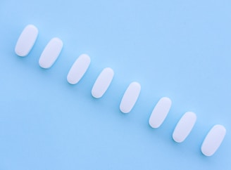 A row of white pills sitting on top of a blue surface