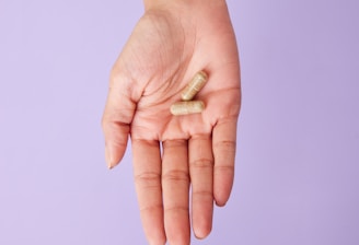 A person holding a pill in their hand